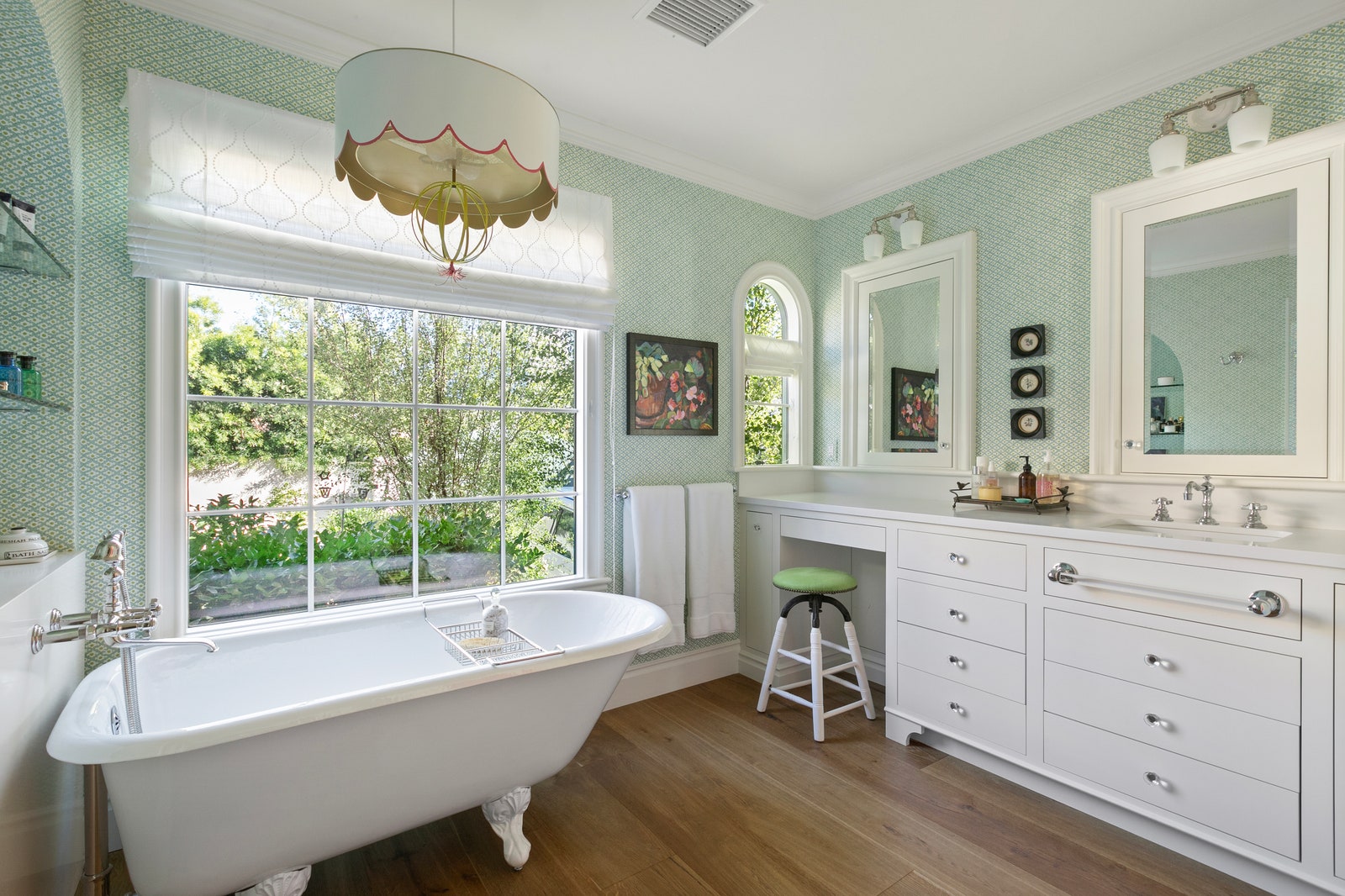 Bathroom of Emma Stones LA home with double vanity white soaking tub mint green patterned wallpaper
